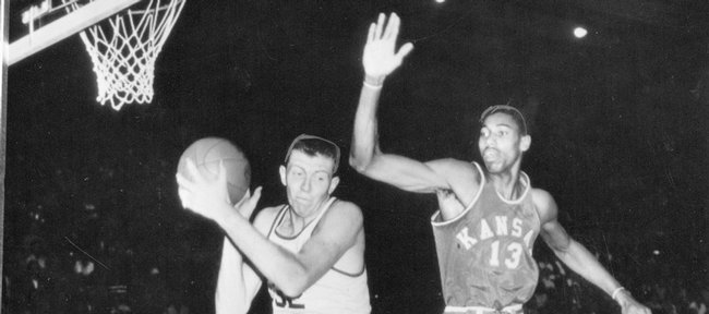 Kansas University basketball player Wilt Chamberlain (#13) defends an SMU player as Gene Elstun (#12) looks on in this March 15, 1957 file photo. Chamberlain and the Jayhawks defeated SMU to record the 800th victory in KU history. The 1957 team went on to finish as the national runner-up.
