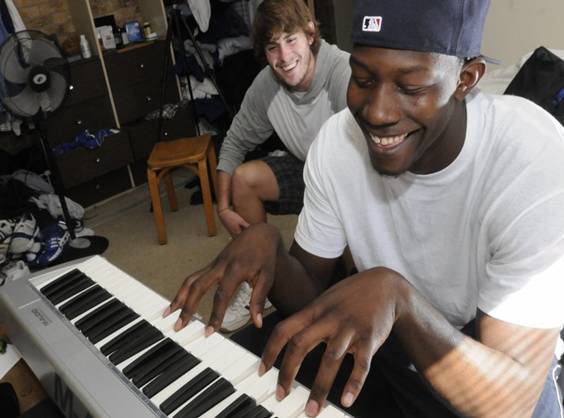 Kansas forward Mario Little cracks a smile as he performs on teammate Conner Teahans keyboard on Wednesday in Teahans apartment in Jayhawker Towers. 