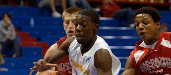 Elijah Johnson, then a member of the north las vegas-cheyenne pump n run elite aau team, blasts through two Missouri Mustang defenders in this May 3 file photo from the Jayhawk Invitational at Allen Fieldhouse. Johnson on Monday signed a letter of intent to play for Kansas University.