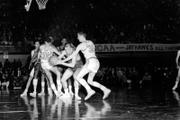 A Kansas University player fights for a rebound with North Carolinas Pete Brennan (35) and Bob Cunningham.